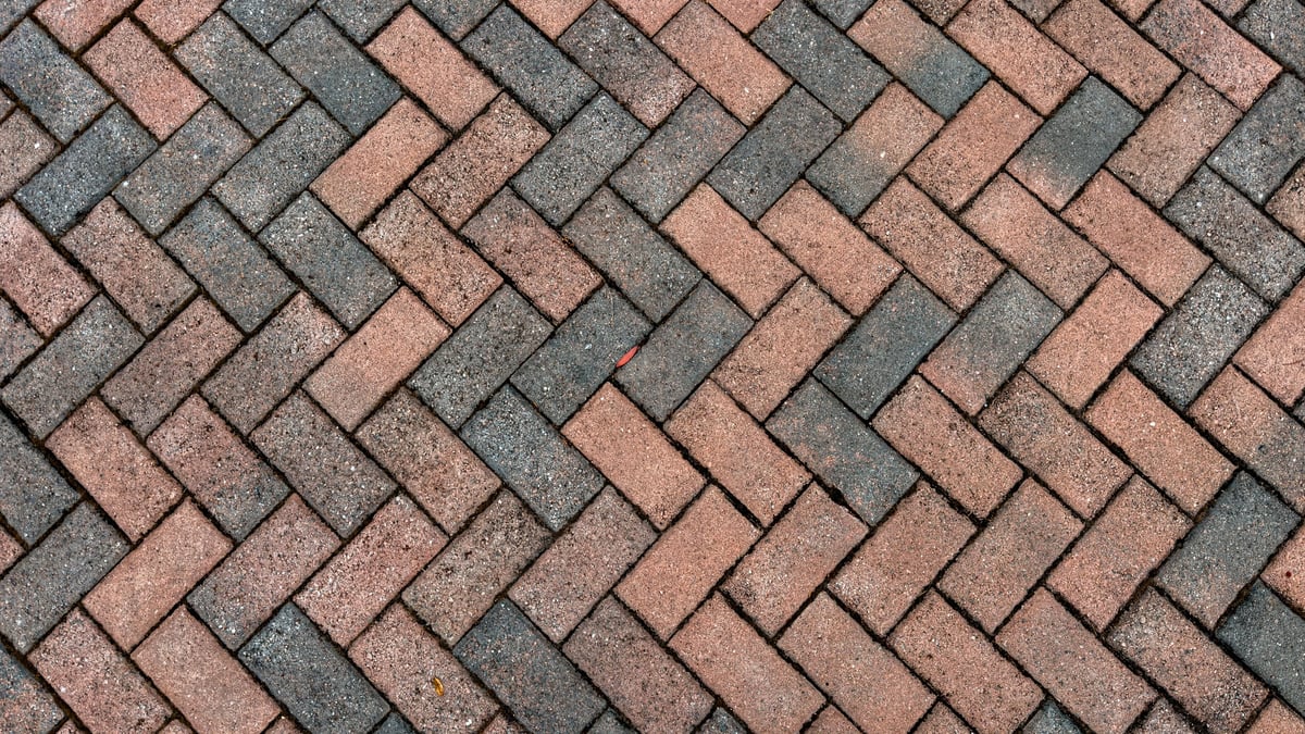 Elegant herringbone brick paver walkway in charcoal and red stone